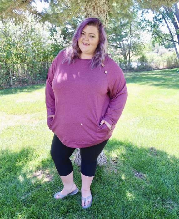 Style maven demonstrates the burgundy iteration's versatility against matte leggings