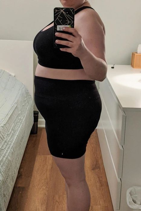A mirror selfie of a reviewer wearing a sports bra and biker shorts