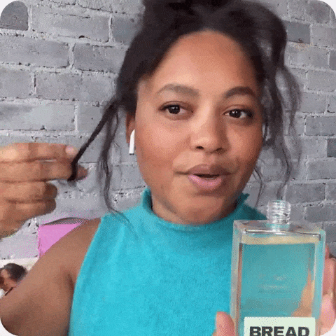 A GIF demonstrating a model applying the hair oil.