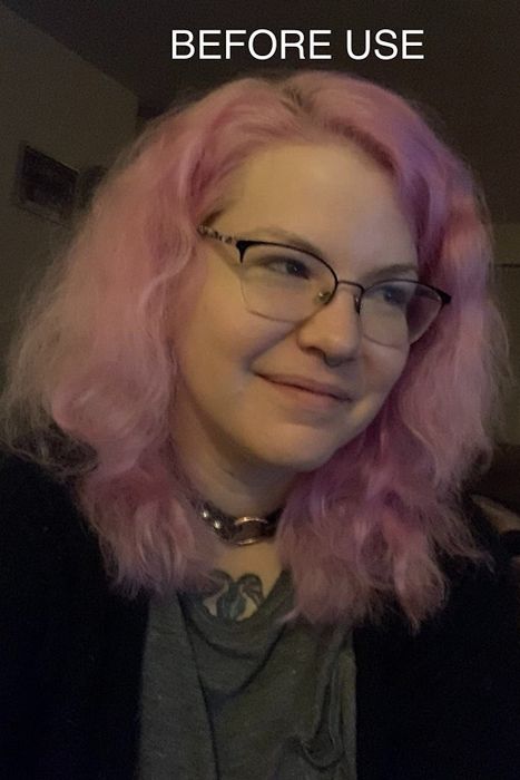 a reviewer showcasing frizzy pink hair before applying the product