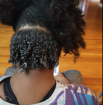 reviewer’s hair with a section of detangled curls and the rest left untouched