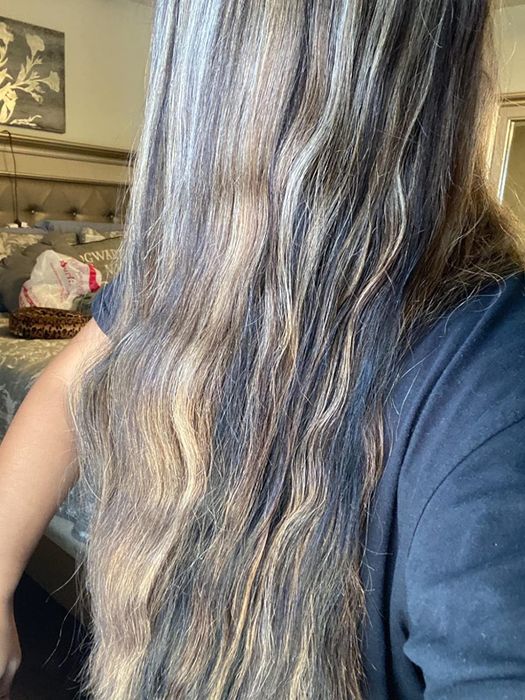 reviewer’s hair before using the product, showing waves and frizz