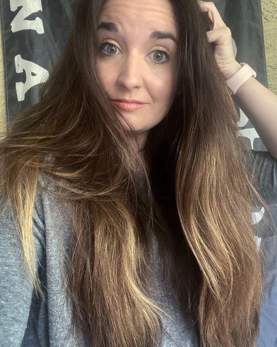A reviewer's photo displaying their hair after using the OGX spray.