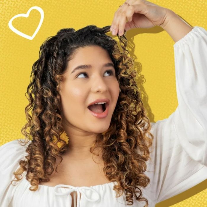 A person proudly showing off their curly hair.