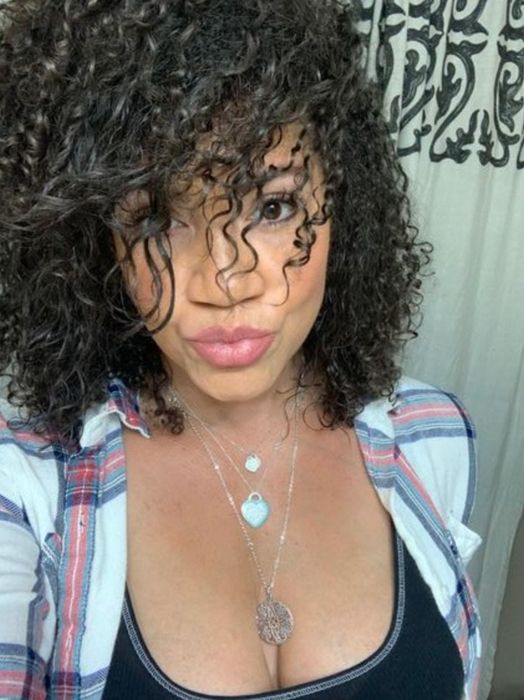 A reviewer showcasing her beautifully defined curls after applying the styling milk