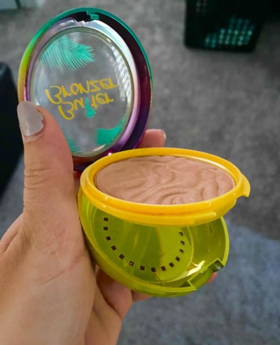 The reviewer is seen holding the sunkissed bronzer