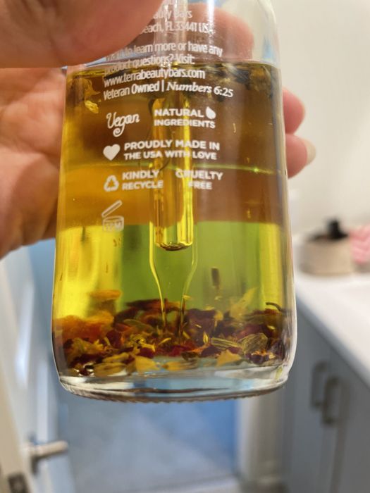A close-up shot showing the petals at the bottom of the bottle of oil.