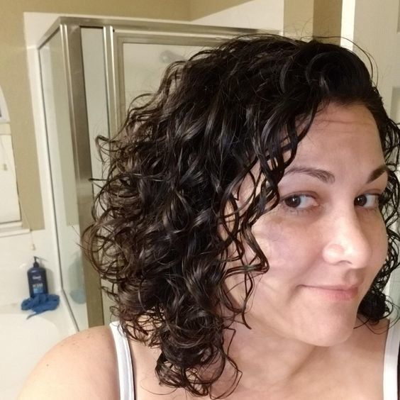 A reviewer with frizz-free, defined curls after using the jelly