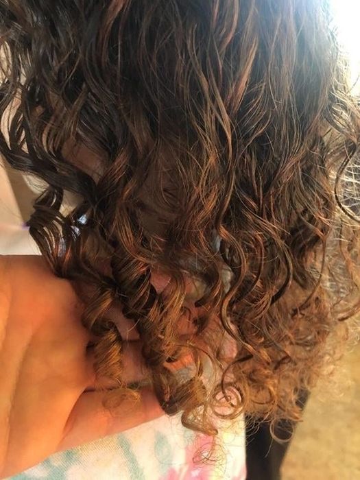 A reviewer showcasing her wet, defined curls