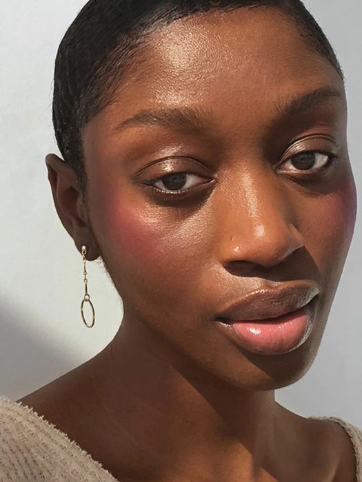 A soft, natural-looking blush applied to a model with darker skin tones.