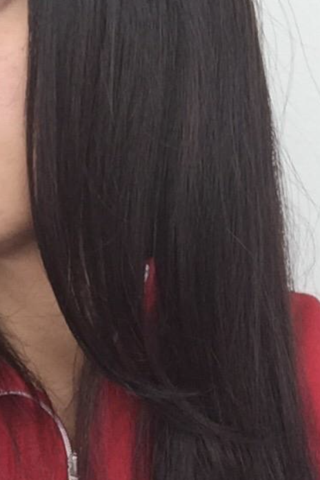 The reviewer's hair is straight and smooth after using John Frieda's frizz serum.