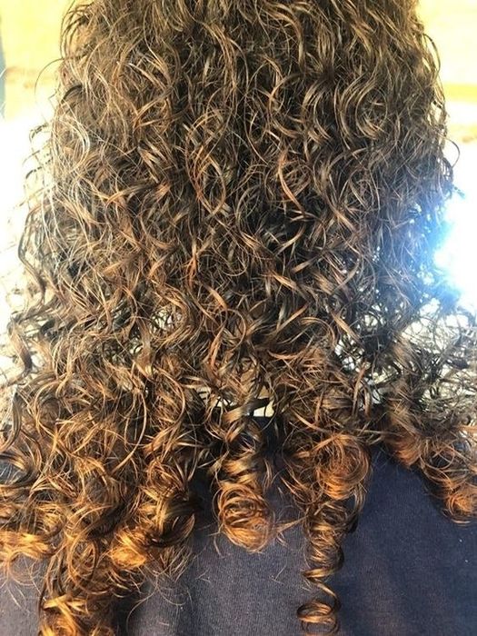 A reviewer with beautifully detangled curly hair after using the brush