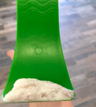 The same reviewer showing the hair removed after scraping off the cream, and there’s quite a bit of it.