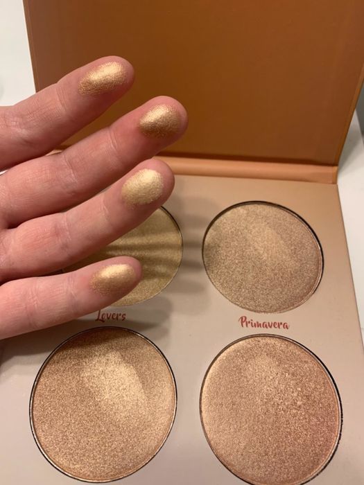 A reviewer is showing off the palette and swatching it on their fingers.
