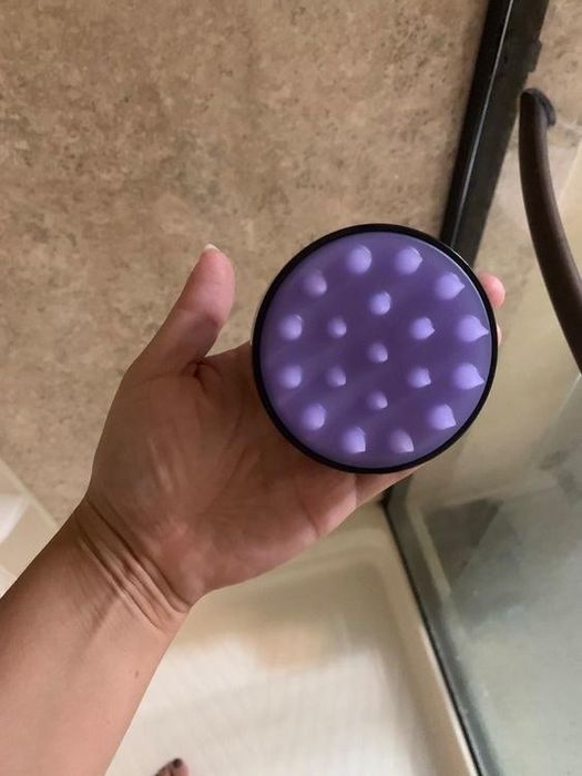 A reviewer holding the scalp brush