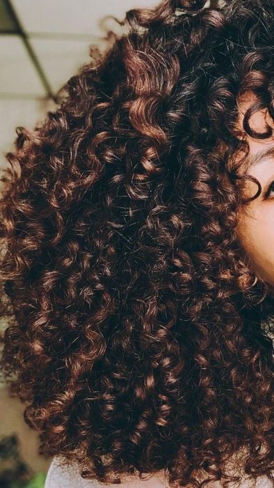 A reviewer showcasing her tight curls after using the activator