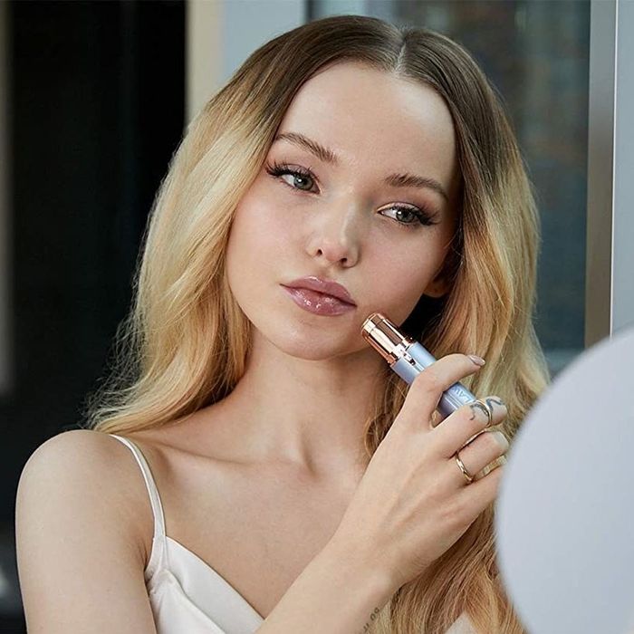 Model using the tool on their cheek