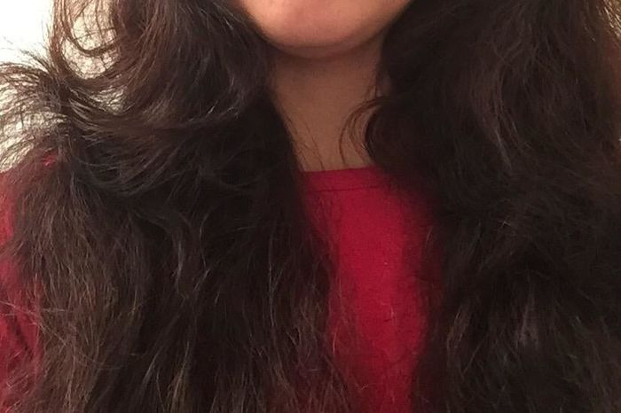 A reviewer shows their frizzy hair before applying the John Frieda frizz serum.