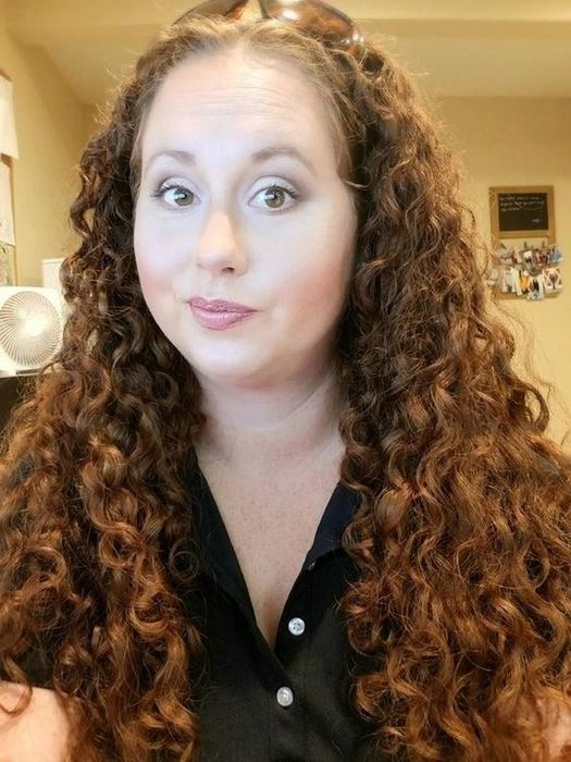 A reviewer displaying her natural curls after using the towel without any additional products