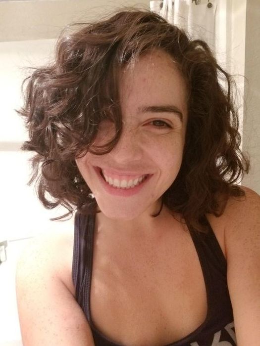 A reviewer with short curly hair showcasing her results after using the gel