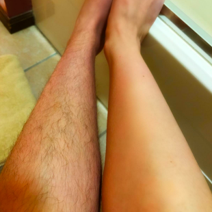 A reviewer showing one leg covered in long hair, while the other is perfectly smooth after shaving.