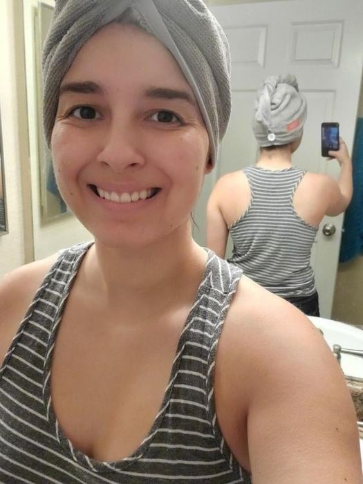 A reviewer wearing the towel, showcasing the button at the back with a mirror
