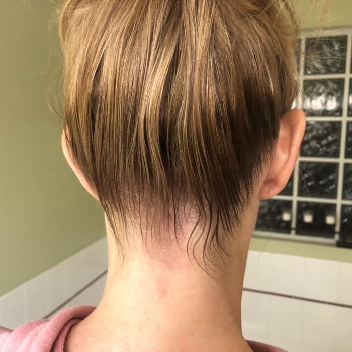 The same individual shows their neater, slicked-back bun after using the hair-finishing stick.