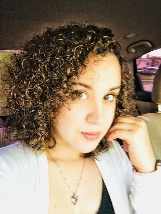 A reviewer showcasing her tightly coiled curls after using the cream