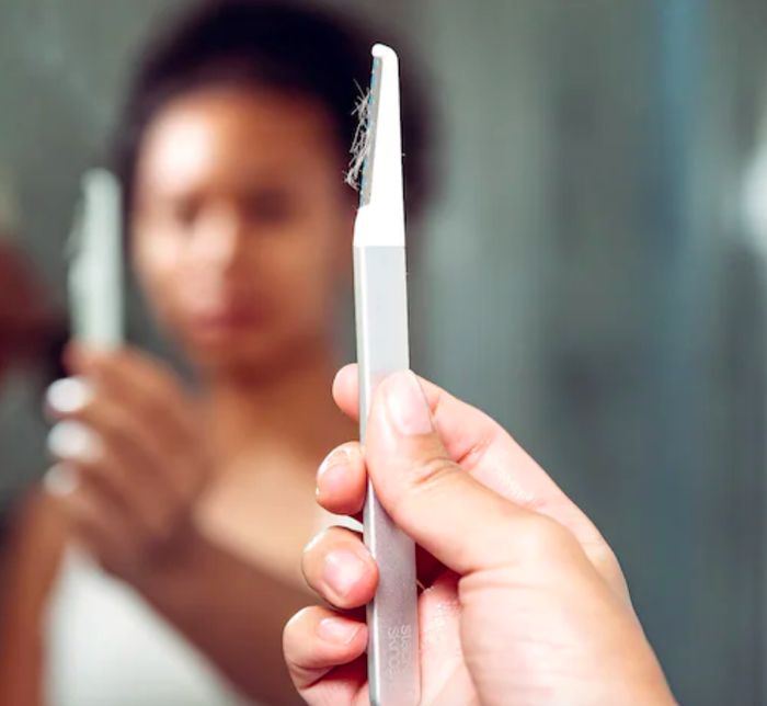 Person holding the tool, with baby hairs attached after use