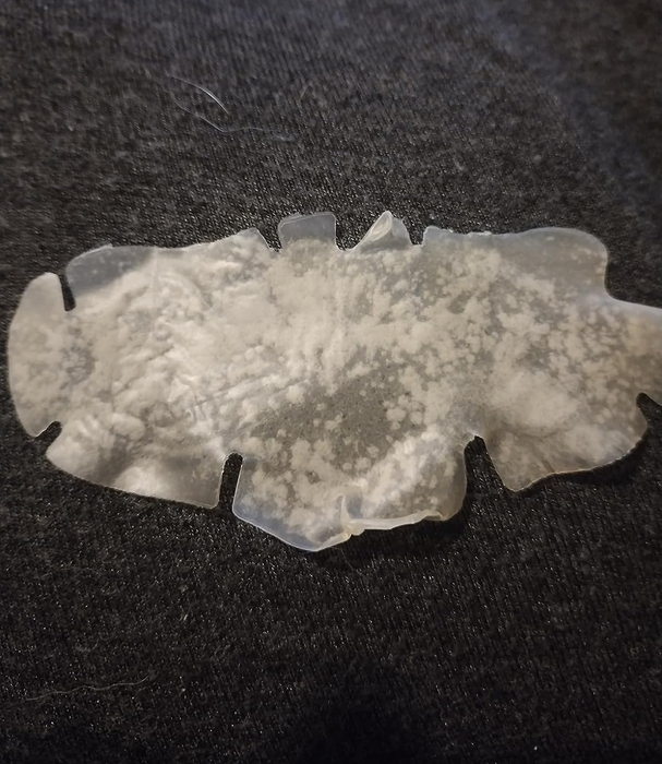 Image of a reviewer holding a used nose patch filled with extracted impurities