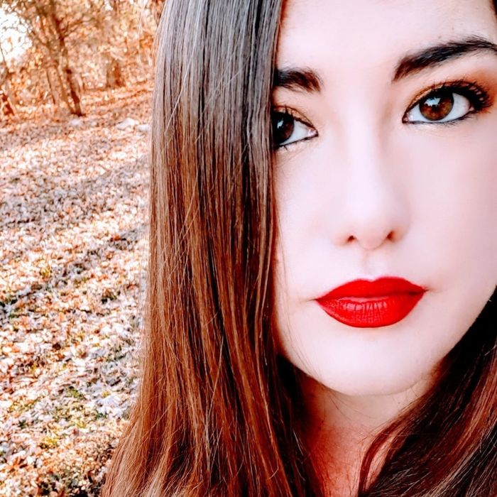 A reviewer with fair skin sporting the vibrant red lipstick.