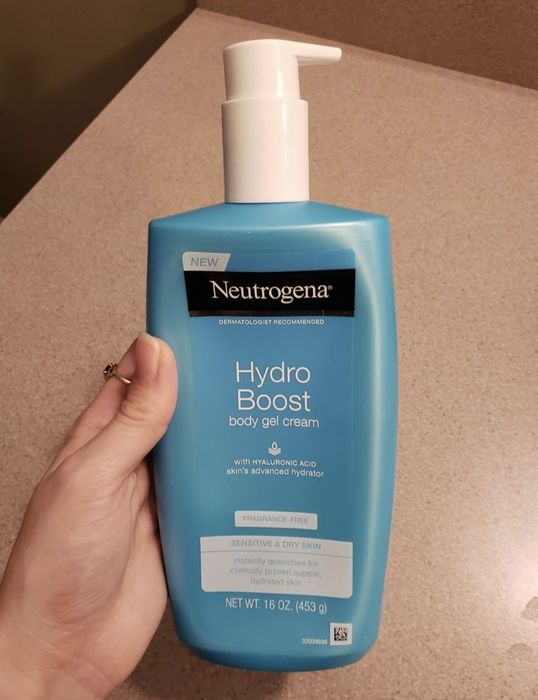 A reviewer is seen holding the product bottle, showcasing its packaging.