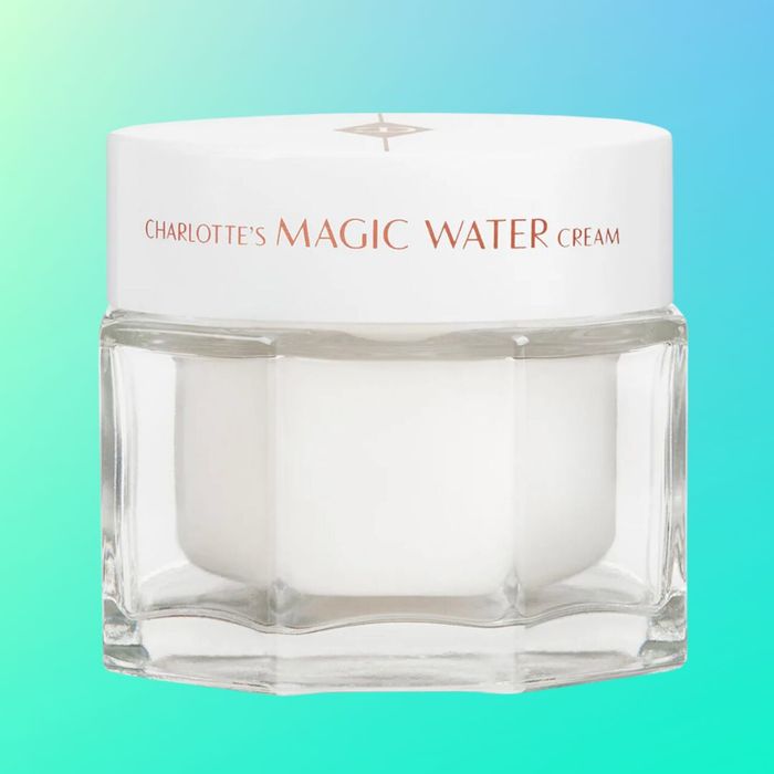 Charlotte's Magic Water Cream, showcased in a transparent jar with a white lid, set against a gradient backdrop.