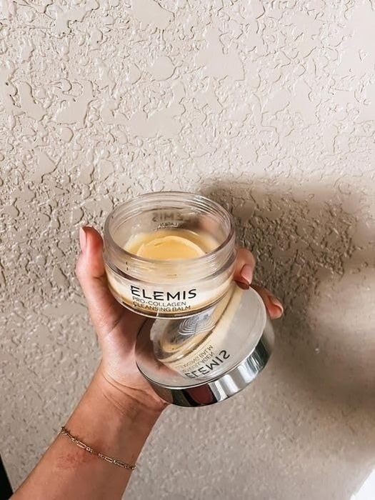 A reviewer's photo of a nearly empty container of the balm