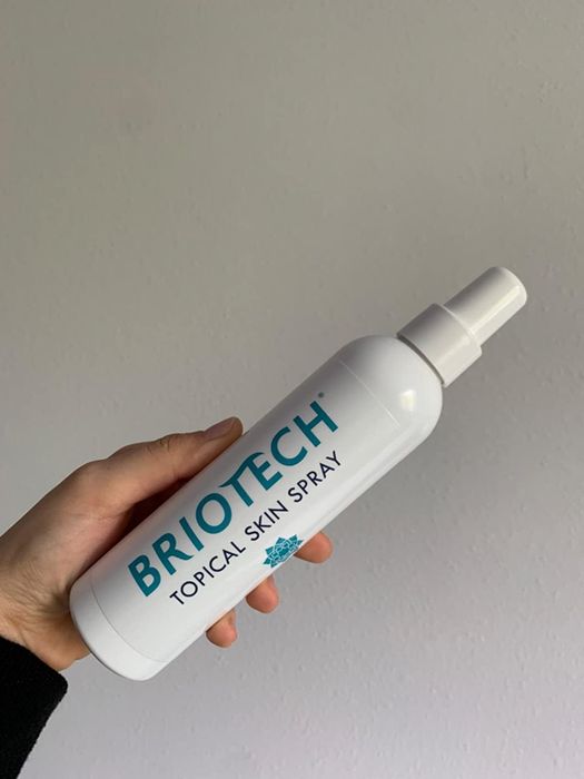 A reviewer holding their bottle of Briotech spray