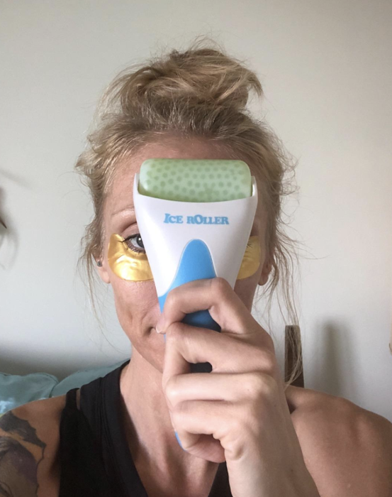 A reviewer is seen gliding the ice roller across their forehead, demonstrating its use for reducing puffiness and soothing the skin.