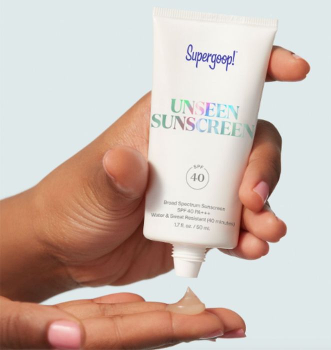 hands squeezing sunscreen from its tube