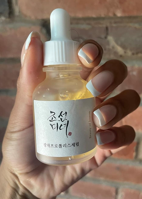 A reviewer holding up the serum bottle in their hand