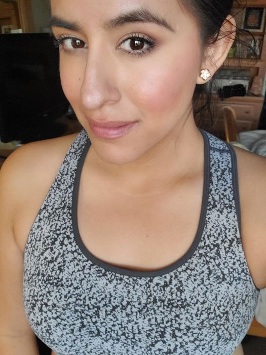 A reviewer wearing the blush in a natural nude pink shade