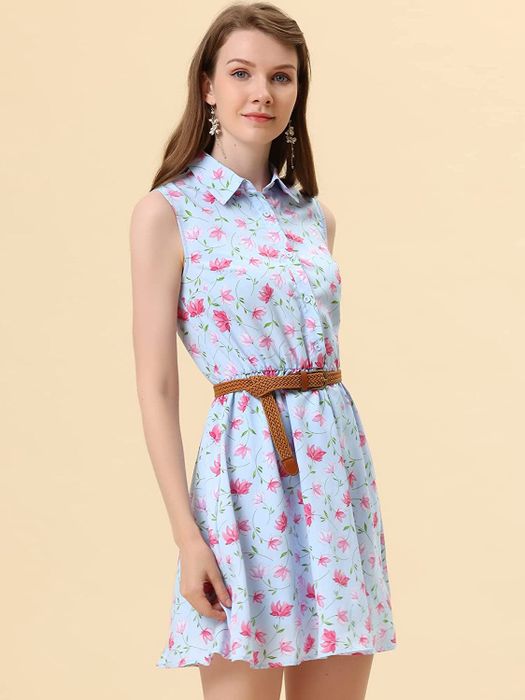 A model in a light blue sleeveless mini shirtdress adorned with pink flowers and a brown braided belt.