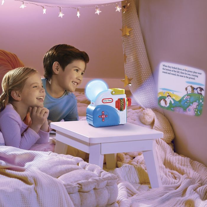 Two children watch in awe as the story projector casts enchanting images on the wall.