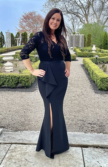 Reviewer wearing a black V-neck lace long sleeve dress with a ruffle slit and mermaid-style skirt, posing outside on stone ground.