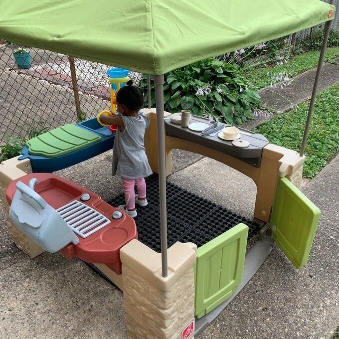 A child having fun with an outdoor toy kitchen set