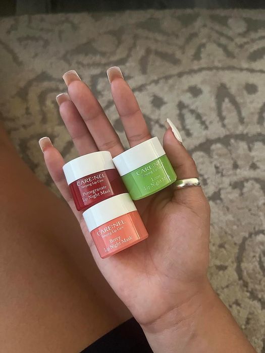A reviewer holding the three different varieties of lip masks.