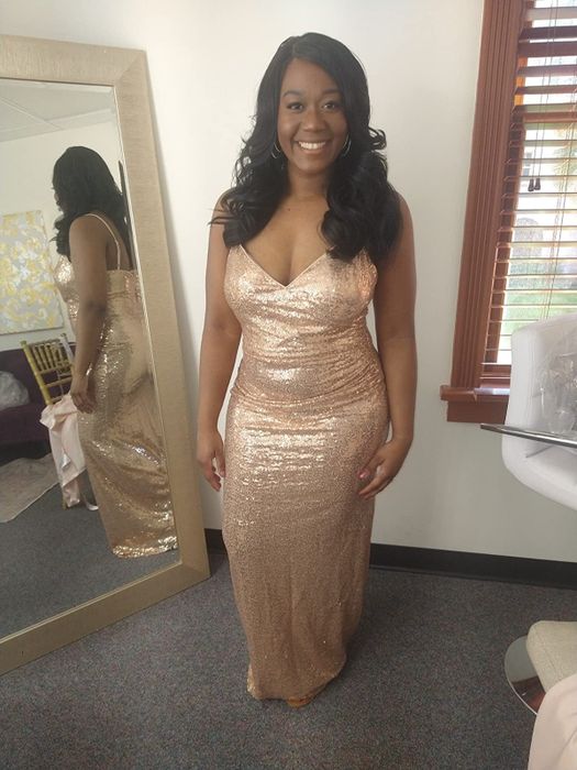 A reviewer in a glittering rose gold mermaid-style maxi dress