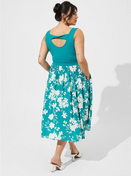 A model showcasing a large cutout detail in the scoop back of the dress.