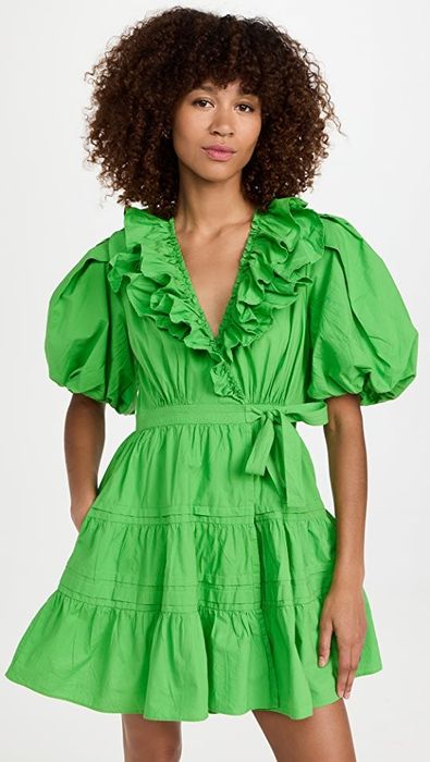 A model wearing a short puff sleeve dress with a ruffled V-neckline.
