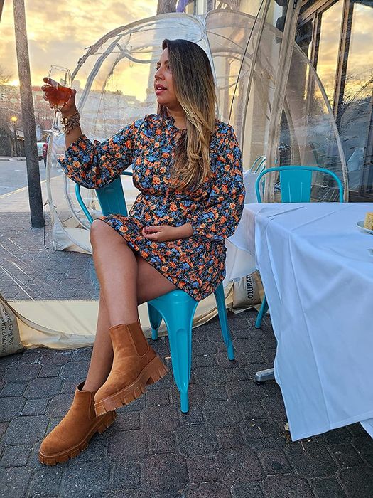 reviewer image in a floral minidress, holding a wine glass