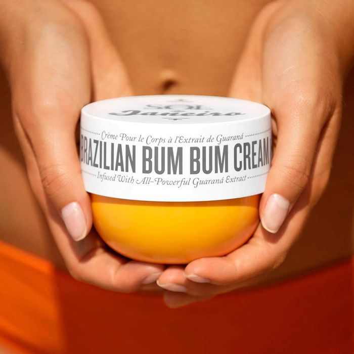A jar of cream held in a model's hands