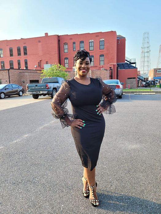 The reviewer is wearing the same dress, but this time in a chic black version.